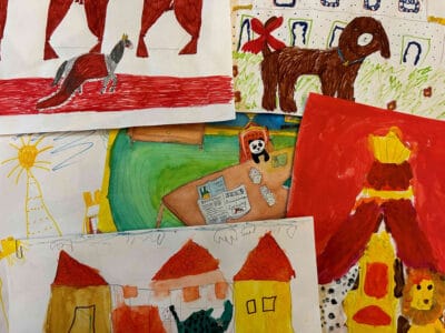 „Impressionen eines Malwettbewerbs für Kinder im Schlossmuseum Braunschweig. Das Bild zeigt verschiedene bunte Zeichnungen von Kindern, darunter Darstellungen von Tieren, Häusern und einem Thron."
